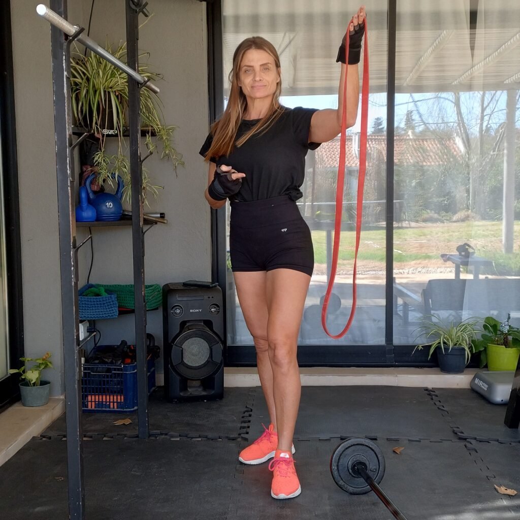 Gaby Schvap en Petit Gym mostrando una banda elástica Theraband, parte del equipamiento utilizado en su espacio de entrenamiento de fuerza.