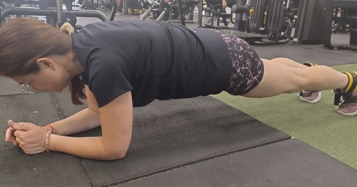 Mujer adulta realizando entrenamiento de fuerza en Pilar con pesas en gimnasio funcional para mejorar masa muscular, estabilidad y salud física después de los 40.