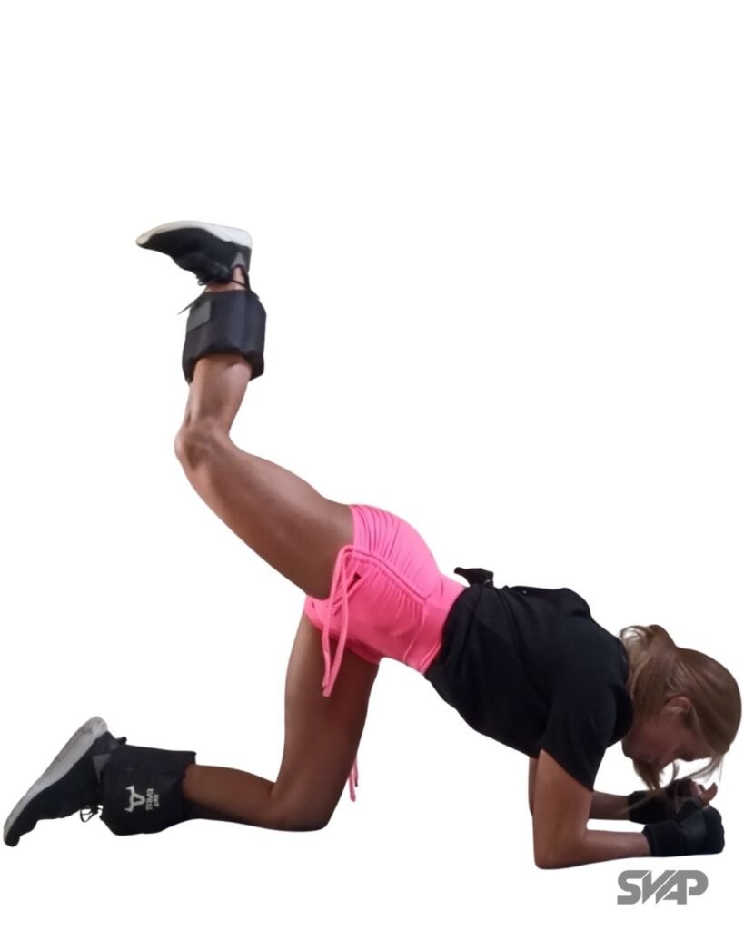Entrenamiento de fuerza: mujer realizando extensión de cadera en cuadrupedia para activación de glúteos