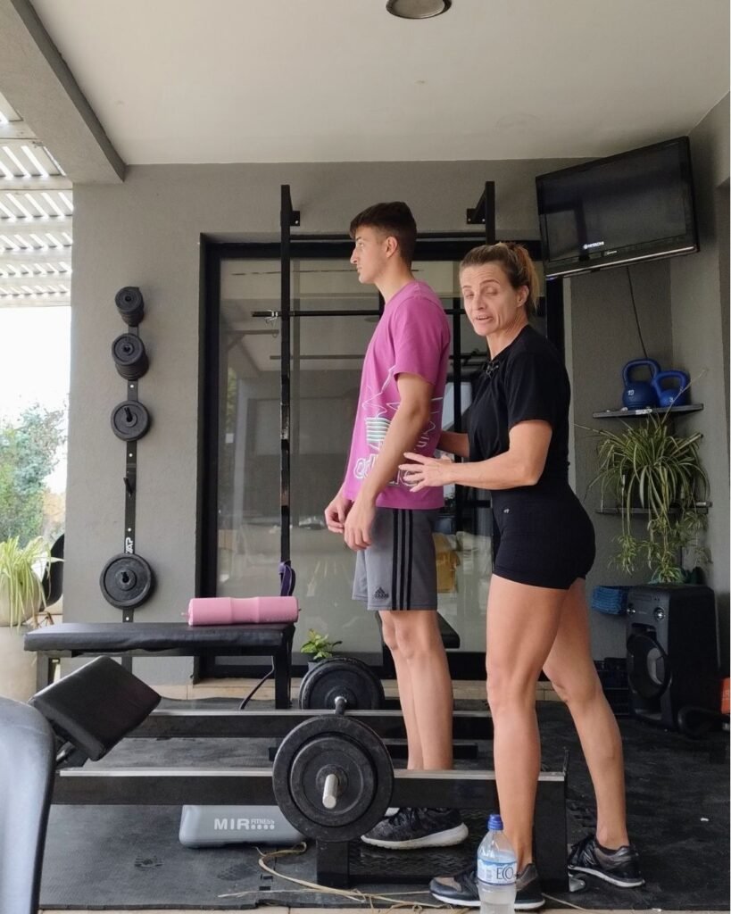 Entrenadora brindando pautas previas a la ejecución de un ejercicio para mejorar la calidad del movimiento y entrenar fuerza de forma segura y consciente.